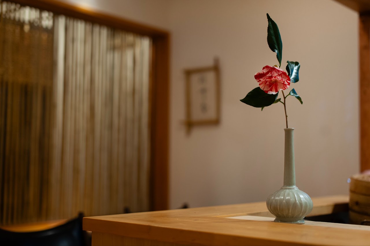 聴雪菴の店内（白木のカウンターと一輪挿し）